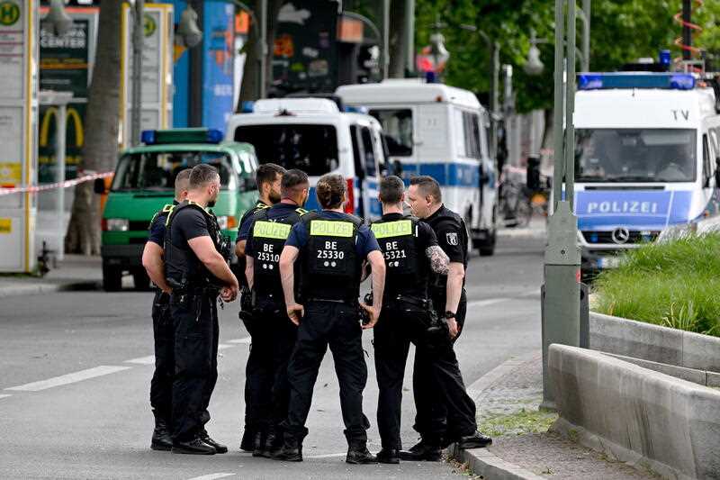 Police officers on guard at the scene where a car drove into a crowd of people in central Berlin, Germany, 08 June 2022