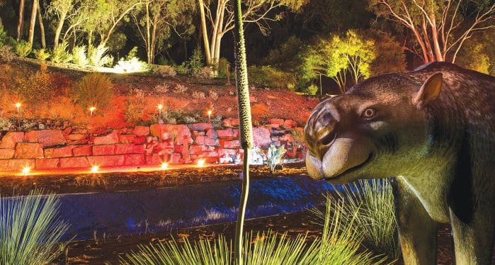 megafauna sculpture in illuminated gardens at night