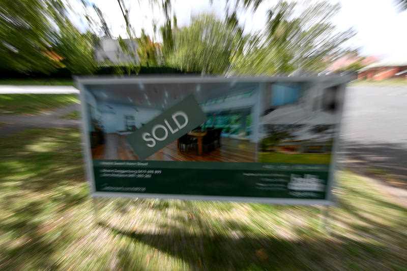 A real estate advertising board with a Sold sign is seen in Canberra,