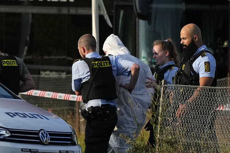 A person in a white DNA suit is taken away by the police, near the Field's shopping center, after a shooting, in Copenhagen, Denmark, Sunday July 3, 2022