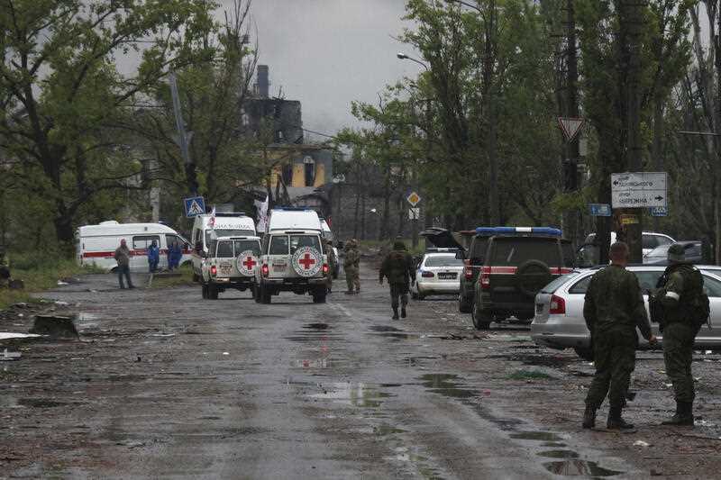 Red Cross vans are seen driving through war-ravaged streets in Ukraine