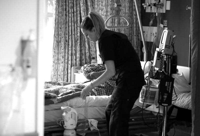 a nurse in Mount Druitt Hospital's palliative care unit tending to a patient.