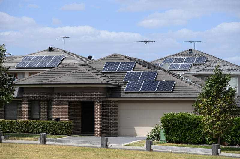 Solar panels are seen on the rooftops of houses in suburban Sydney
