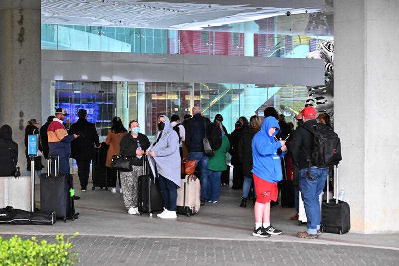 Passengers waiting to be let in to the checkin counters after a shooting where a man fired at least 3 shots from a pistol at Canberra Airport in Canberra, Sunday, August 14, 2022.