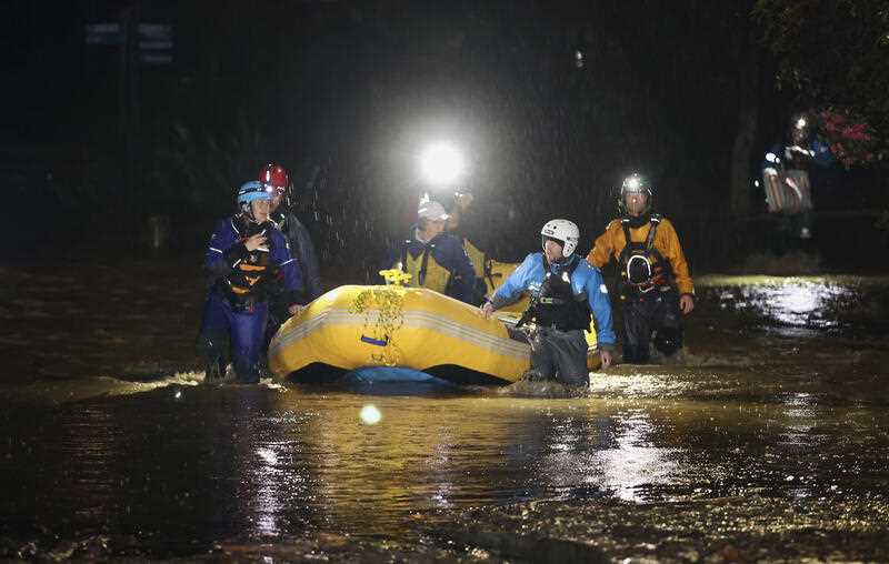 Emergency workers use an inflatable boat to rescue stranded residents in Nelson, New Zealand