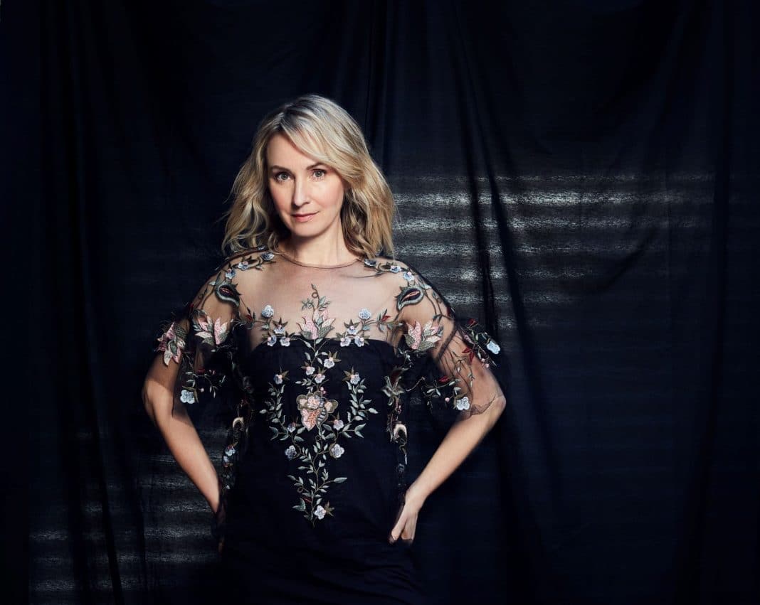 Renowned Australian actress Lisa McCune is seen wearing a black evening dress and and smiling at the camera
