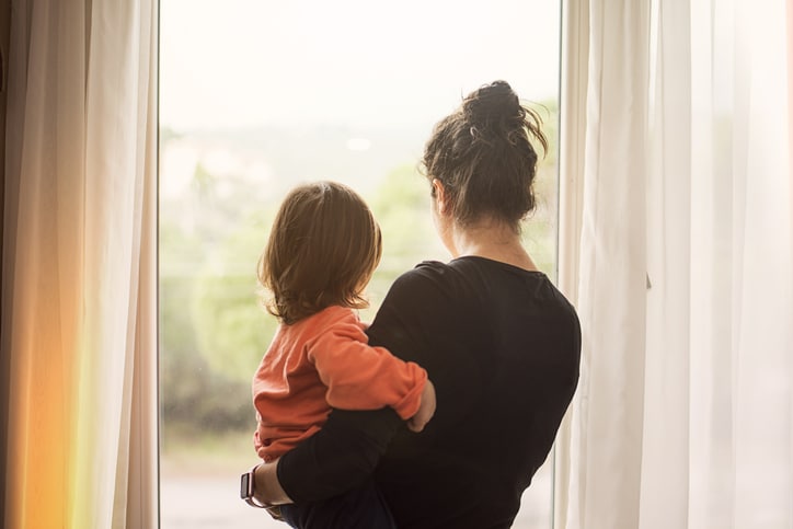 Mother and toddler looking out of window