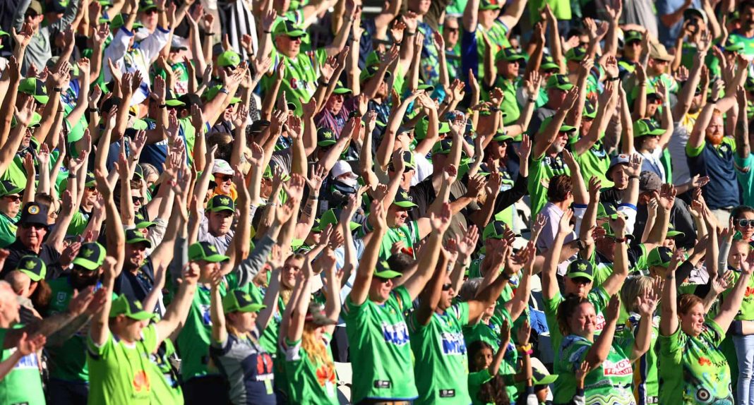 scores of Canberra Raiders fans in green jerseys performing the Viking clap at Canberra stadium
