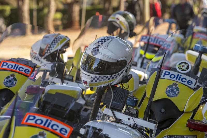 Multiple Queensland Police motorbikes and helmets are seen parked at a funeral for a slain police officer