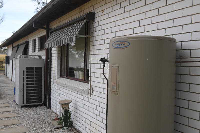 a hot water system and an industrial size air conditioning unit are seen outside a home in Sydney