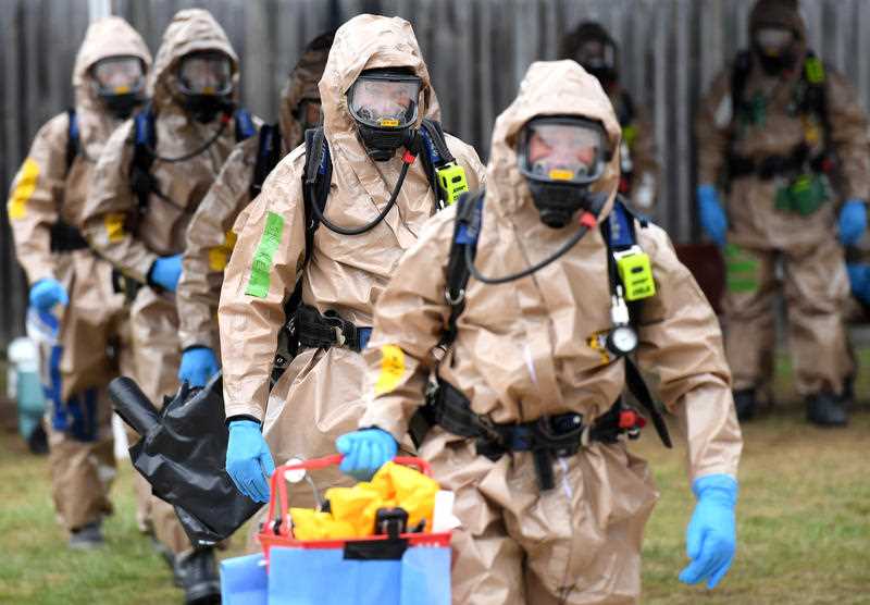 Emergency crews in anti-contamination safety gear