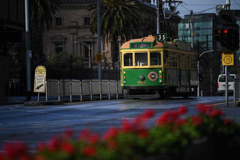 A City Circle tourist tram is seen along a near empty road in Melbourne