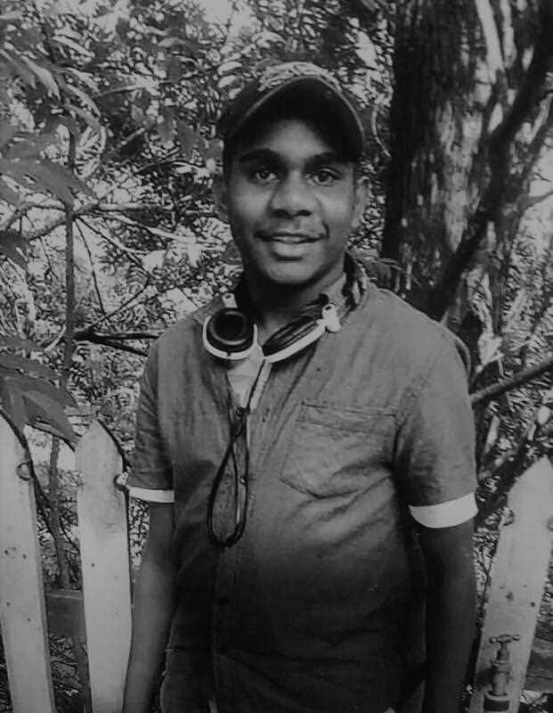 black and while snapshot of teenage Aboriginal male Kumanjayi Walker in a garden seen smiling at the camera