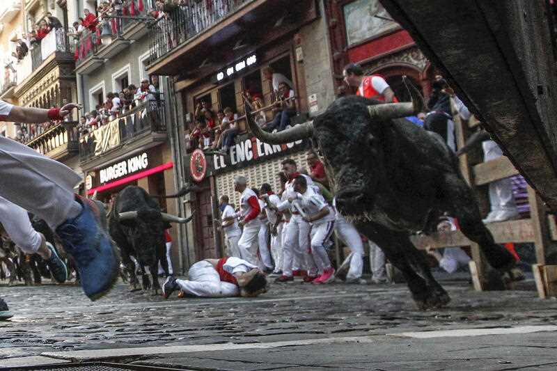 People take part in the traditional running of the bulls during the San Fermin Festival in Pamplona, Navarra, Spain