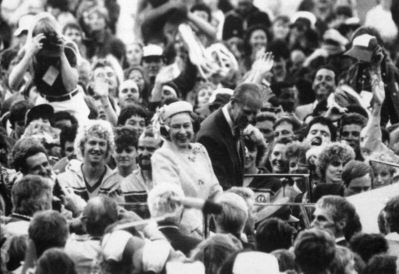 In this Oct. 9, 1982 file photo, Britain's Queen Elizabeth II, centre and her husband Prince Philip react, as they drive through the crowd of athletes and officials during the Closing Ceremony of the 12th Commonwealth Games in Brisbane