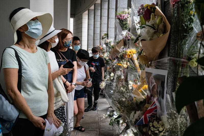 People wait in line to pay tribute to Queen Elizabeth II outside the British Consulate in Hong Kong, Friday, Sept. 16, 2022