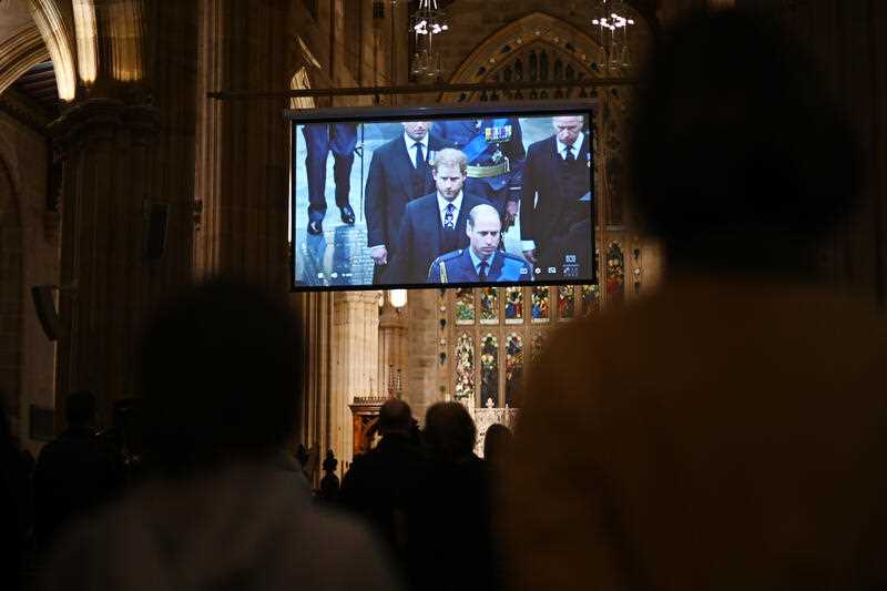 Members of the public watch a live stream of Queen Elizabeth II's state funeral during a Memorial Service at St Andrew's Cathedral in Sydney, Monday, September 19, 2022