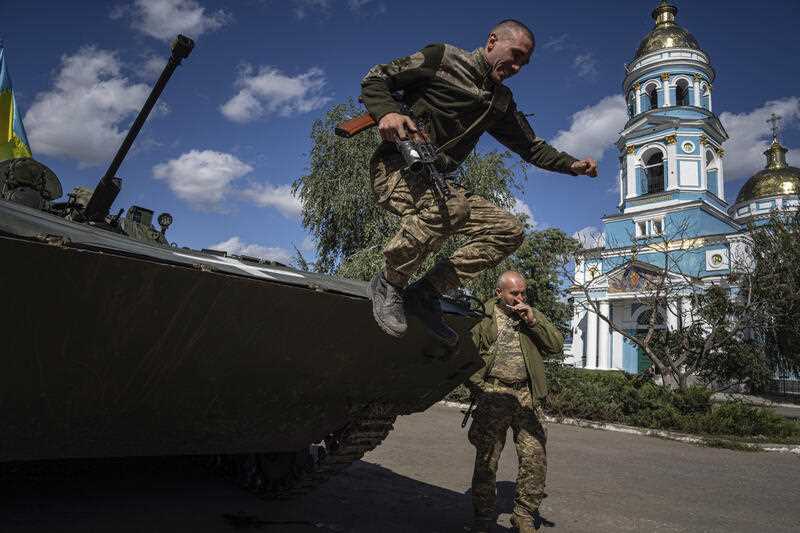 A Ukrainian serviceman jumps from an armored personnel carrier in the recently retaken area of Izium, Ukraine, Monday, Sept. 19, 2022.