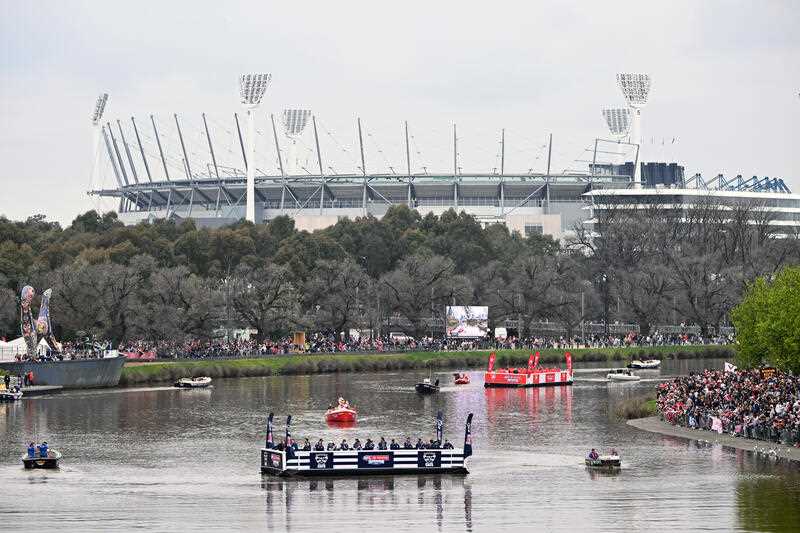 Geelong Cats (left) and Sydney Swans players are seen on a pontoon along the Yarra River during the 2022 AFL Grand Final Parade, in Melbourne, Friday, September 23, 2022