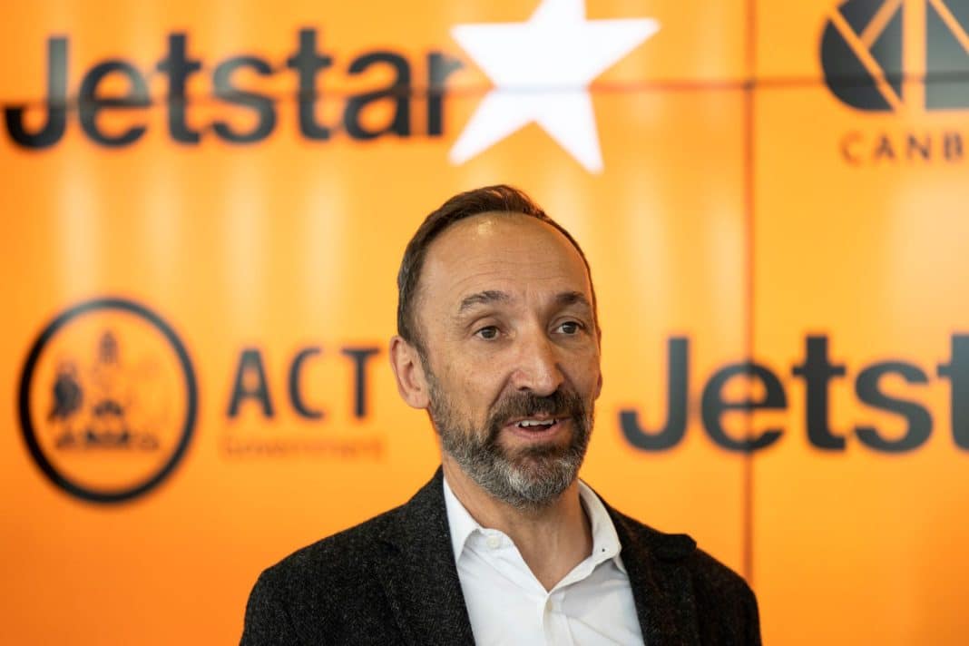Jetstar CEO Gareth Evans is seen in front of orange Jetstar signage