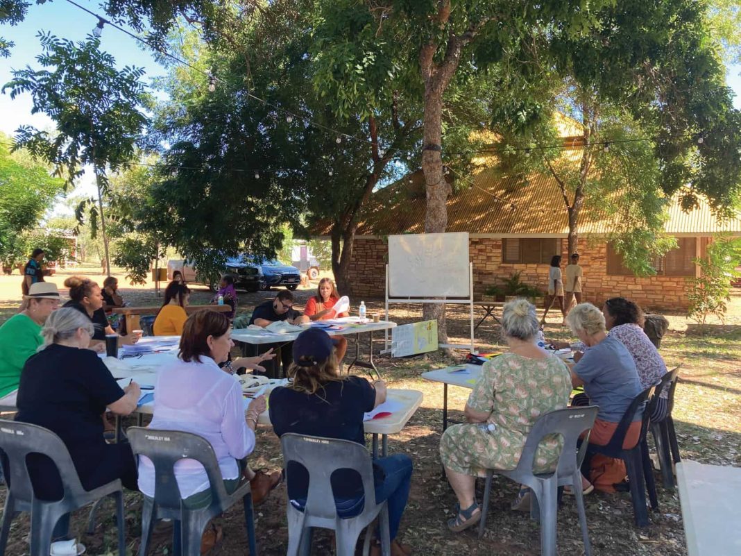 people are seen sitting at an outdoor workshop