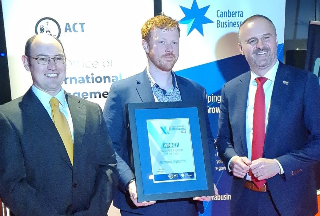 Three business men in suits, one holding a 2022 ACT Export award certificate