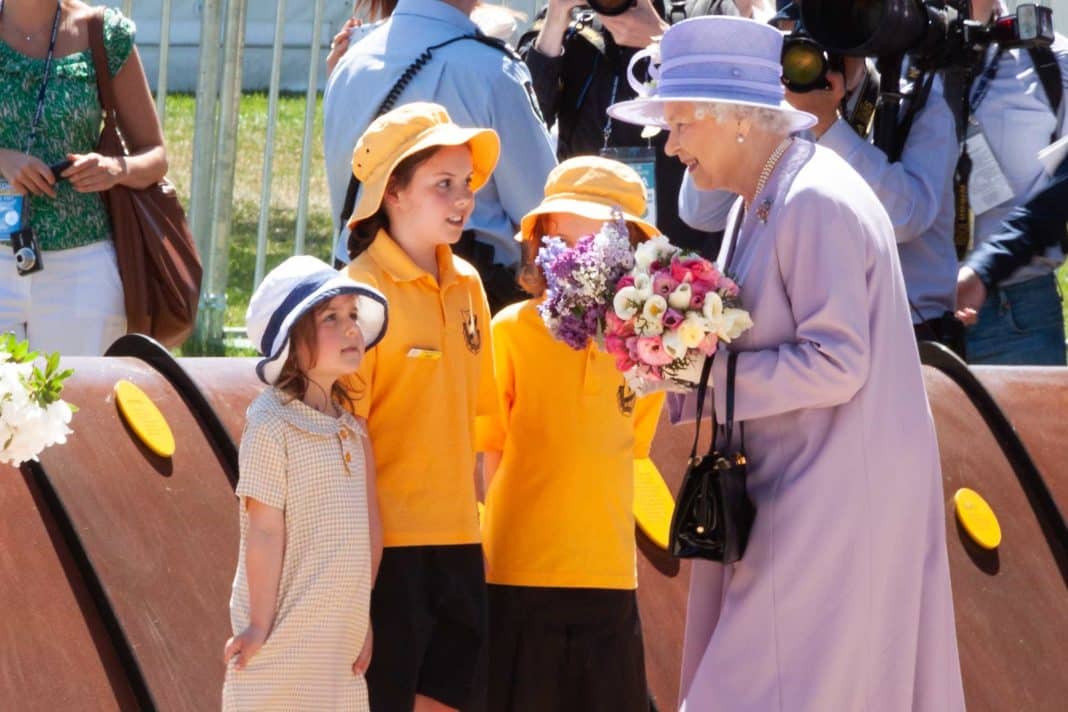 3 little girls giving flowers to the Queen in Canberra