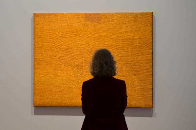 A visitor looks at an artwork in a gallery