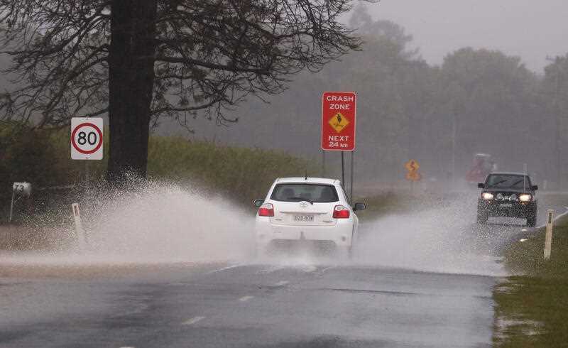 2 cars splashing through rainwater on the road