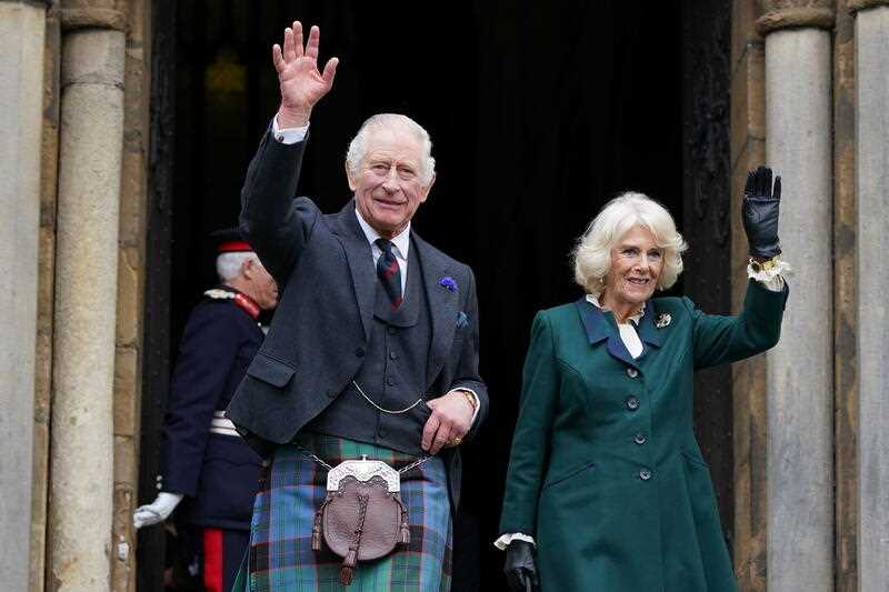 Britain's King Charles III and Camilla, the Queen Consort, wave as they leave Dunfermline Abbey