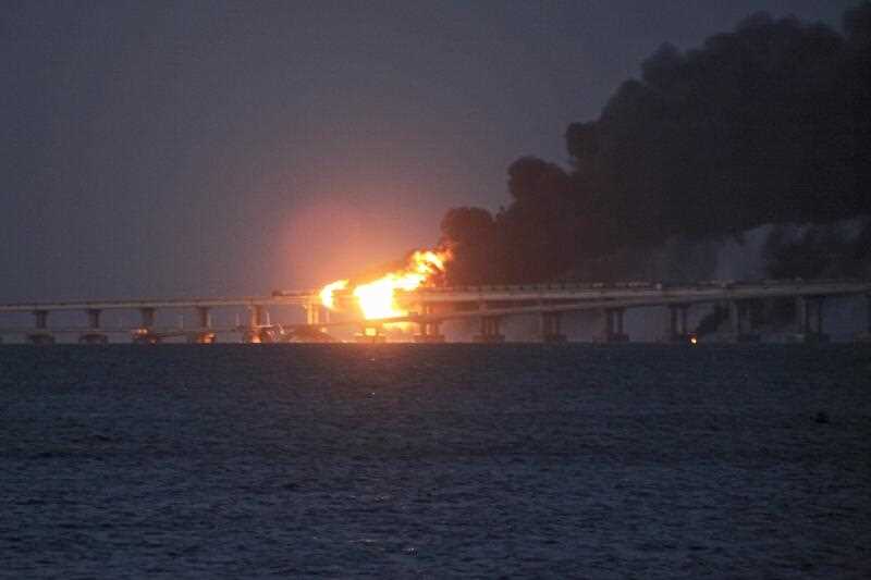 Flame and smoke rise from the Crimean Bridge connecting Russian mainland and the Crimean peninsula over the Kerch Strait