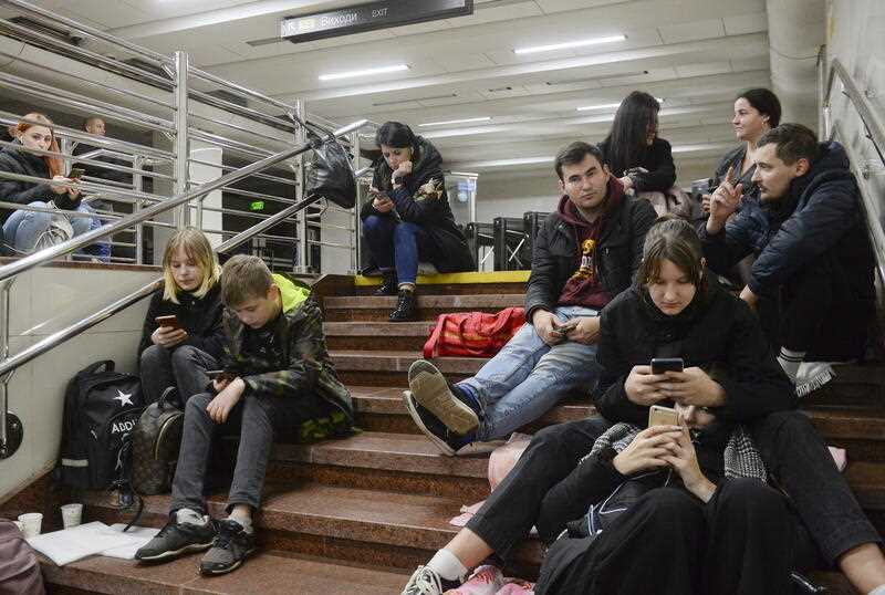 People check their phones as they shelter inside a metro station after a shelling in Kyiv (Kiev), Ukraine, 31 October 2022,