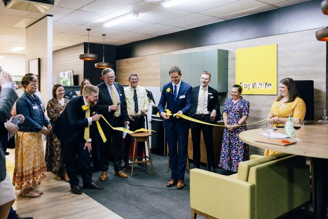 group of several people cutting yellow ribbon to officially open the new Ray White Rural office in Yass