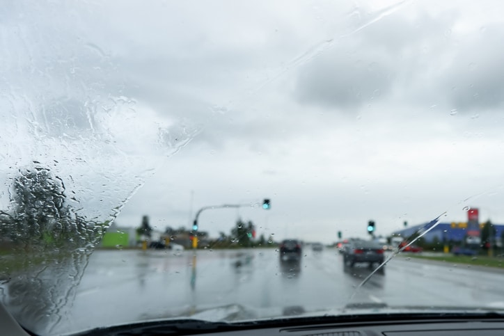 Blurred defocused image of the rain through the windscreen in Australia. Rain on the road background