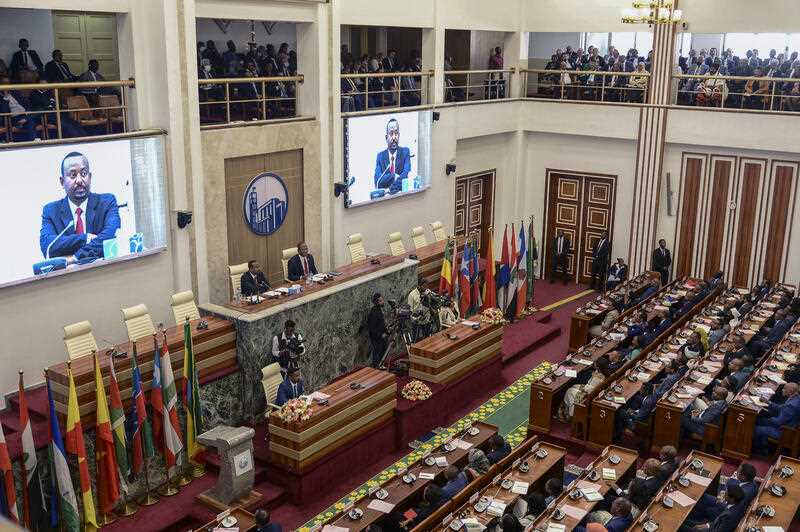 Ethiopia's Prime Minister Abiy Ahmed, center-left on podium and seen on video screens, accompanied by House speaker Tagesse Chafo, center-right on podium, addresses the parliament in the capital Addis Ababa, Ethiopia Tuesday, Nov. 15, 2022