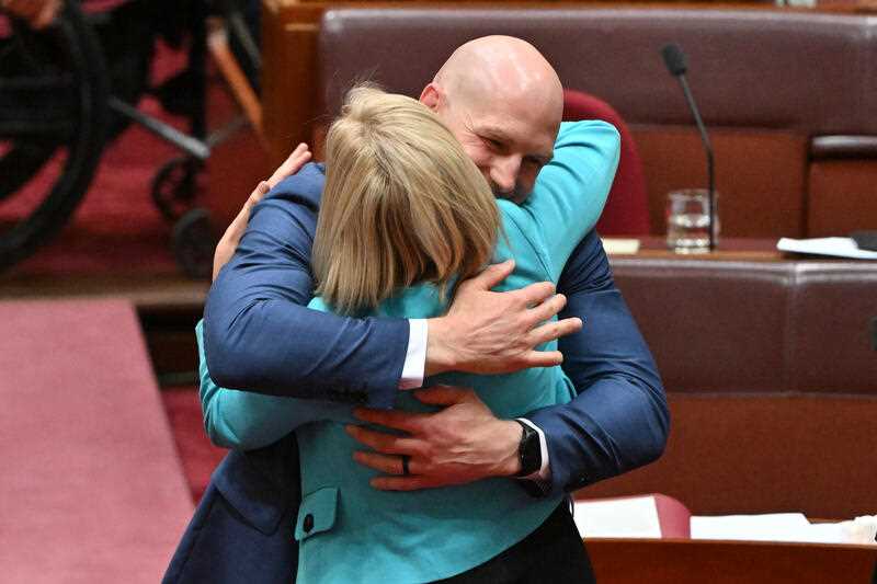 Independent senator David Pocock and Minister for Finance Katy Gallagher hug after the vote on the Territory Rights Bill in the Senate chamber at Parliament House in Canberra, Thursday, December 1, 2022