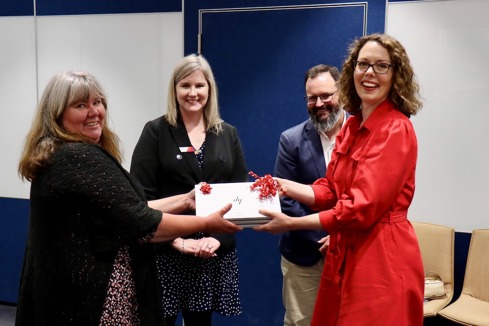 Alicia Payne MP (right) gives a laptop to Kirsty Baker (left), Holy Cross Tuckerbox, watched by Synergy Group's Jeanette Dyer and Gavin Jackson. Photo provided