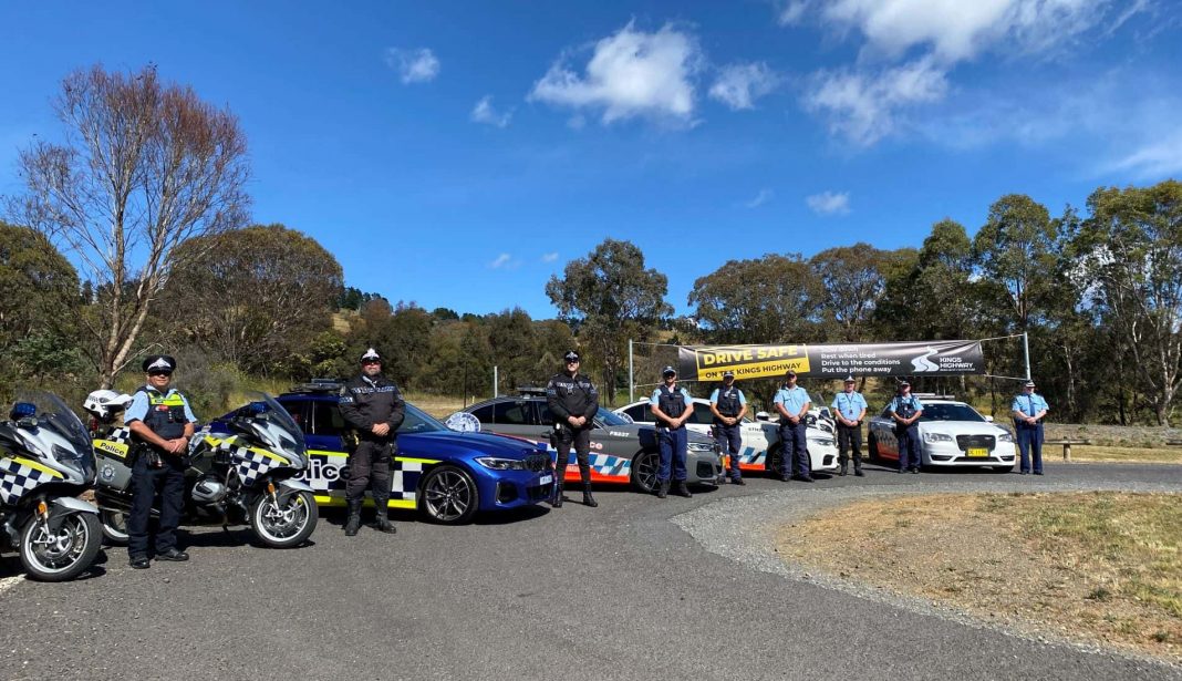 several ACT and NSW police officers stand alongside various police vehicles