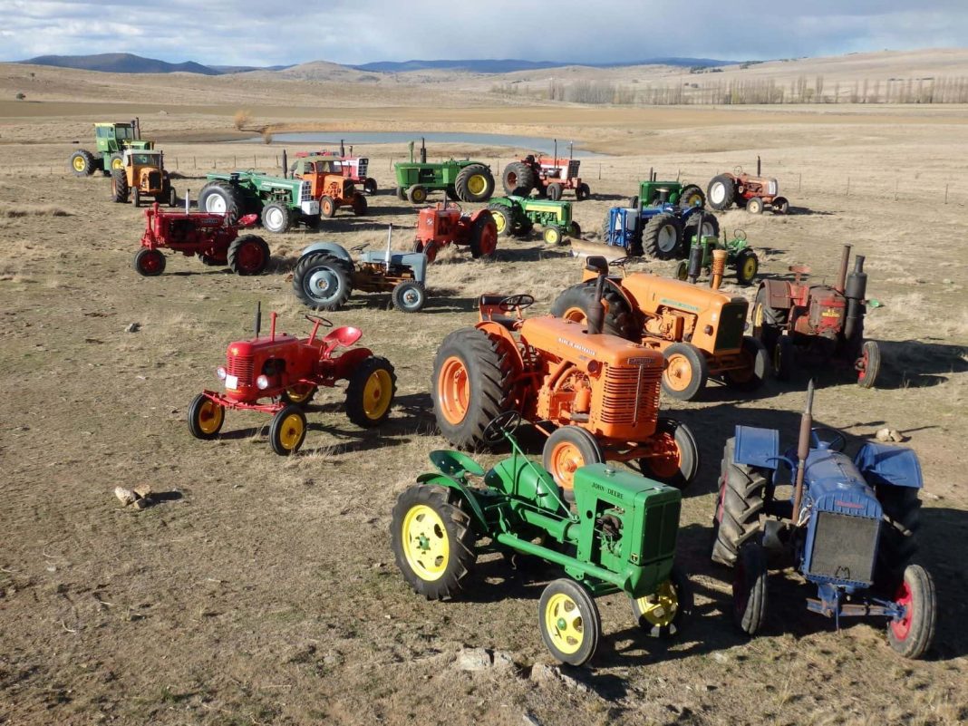 Dozens of tractors parked in a bare paddock