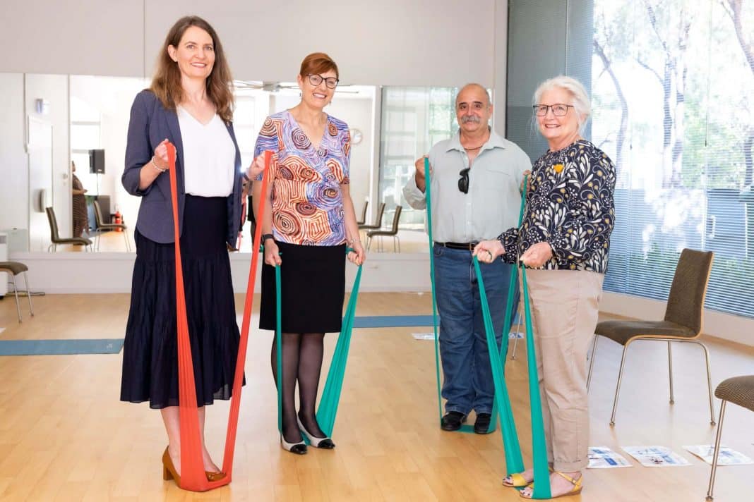 4 adults using resistance bands to exercise while standing