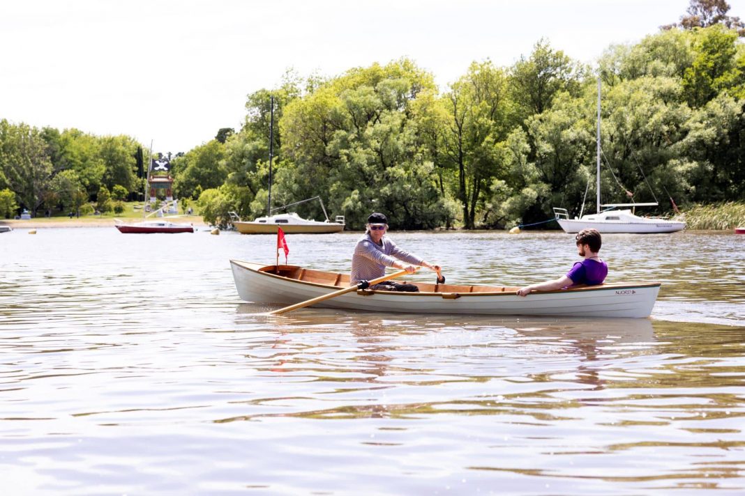 two men in traditional rowing boat on Lake Burley Griffin