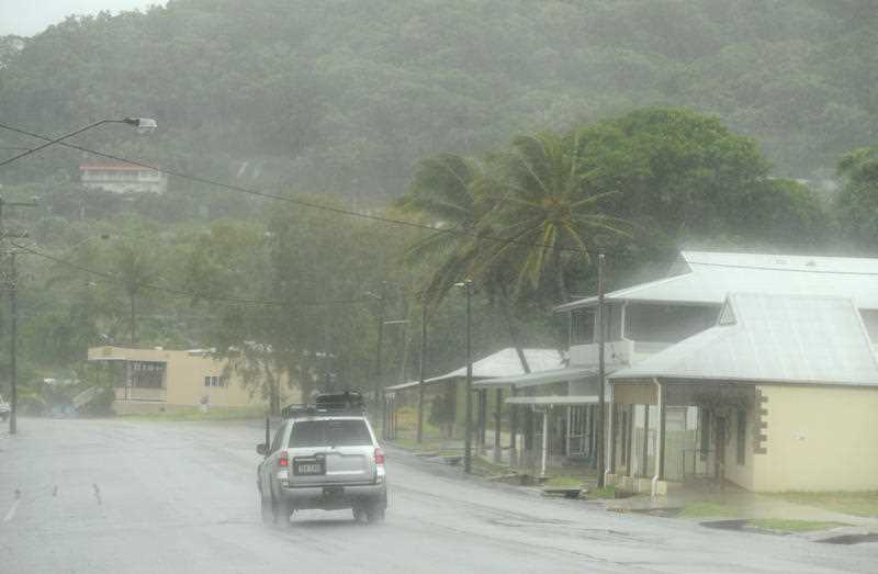 A car drives through torrential rain as the weather closes in on Cooktown in Far North Queensland