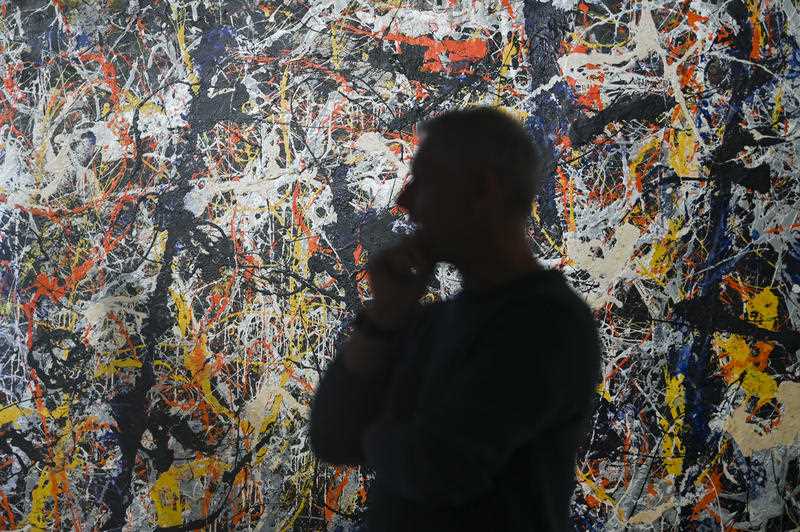 National Gallery of Australia Senior paintings conservator David Wise inspects the paintwork of 'Blue Poles' by American artist Jackson Pollock during conservation work at the National Gallery of Australia in Canberra