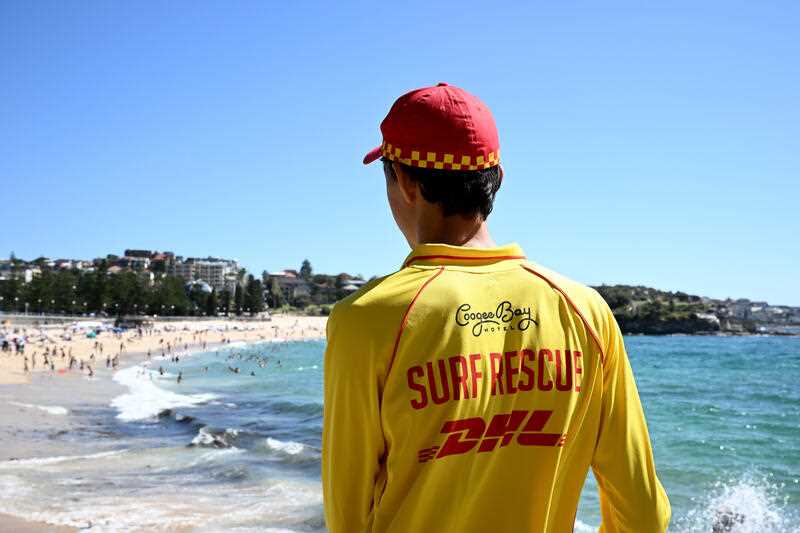 A volunteer surf lifesaver looks out at Coogee beach during a press conference at Coogee Surf Life Saving Club in Sydney