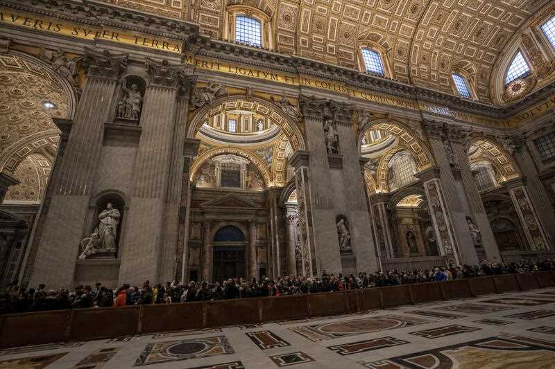 Mourners queue to view the body of Pope Emeritus Benedict XVI as it lies in state inside St. Peter's Basilica at The Vatican where thousands went to pay their homage Monday, Jan. 2, 2023