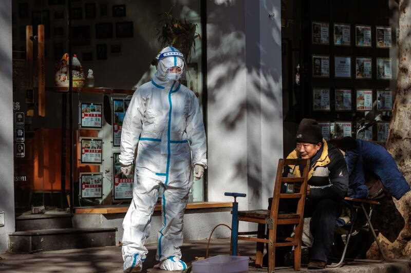A woman in protective gear stands on the street, in Shanghai, China, 04 January 2023
