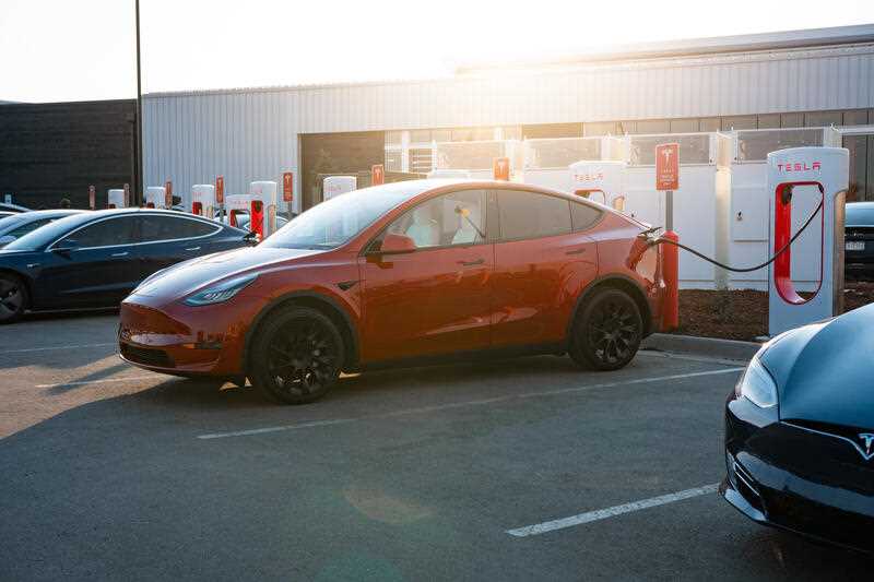 electric cars being recharged at Tesla Supercharger outlets