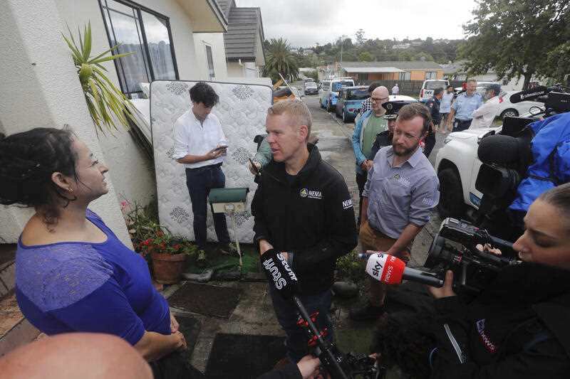 New Zealand Prime Minister Chris Hipkins, center, talks to residents affected by flooding in Auckland, Saturday, Jan. 28, 2023