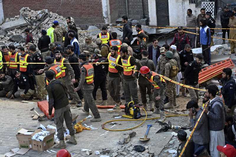 Security officials and rescue workers gather at the site of suicide bombing, in Peshawar, Pakistan, Monday, Jan. 30, 2023