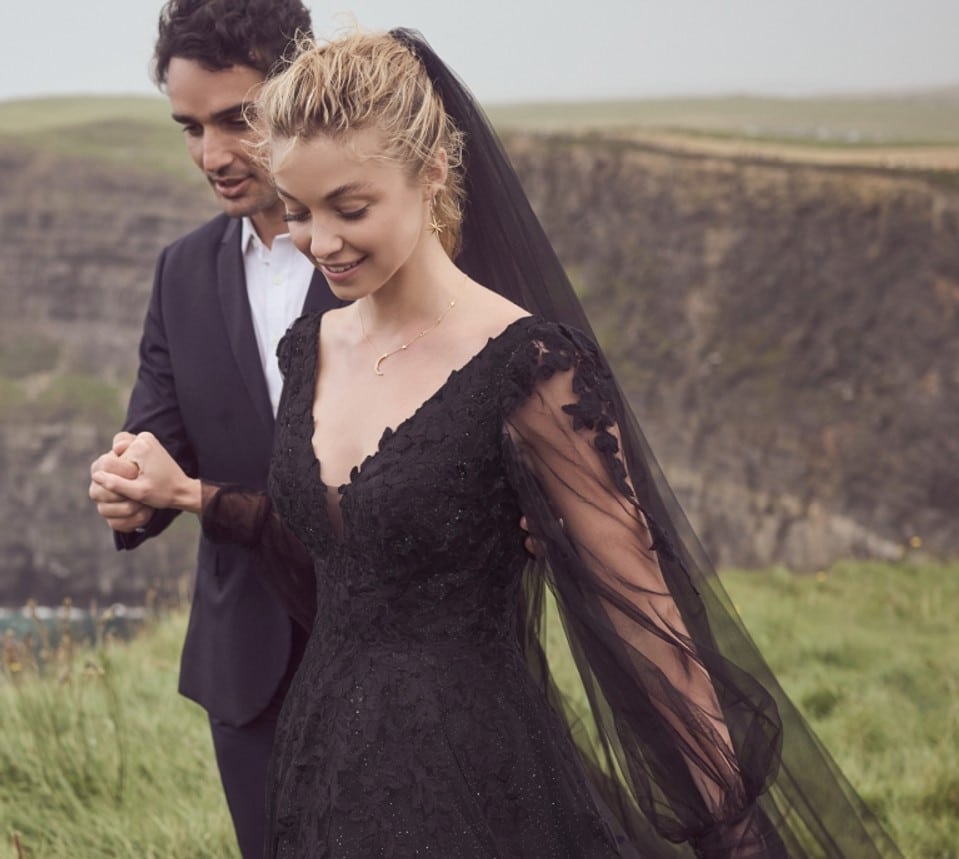 bride in long black lace gown accompanied by groom